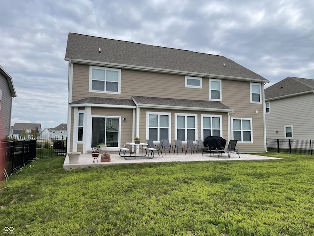 rear view of house with a patio and a lawn