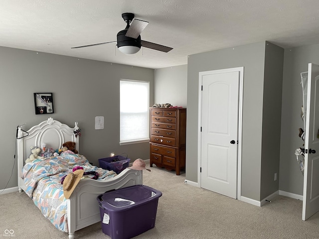 carpeted bedroom with ceiling fan and a textured ceiling