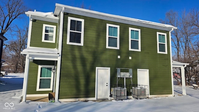 snow covered house with central AC unit