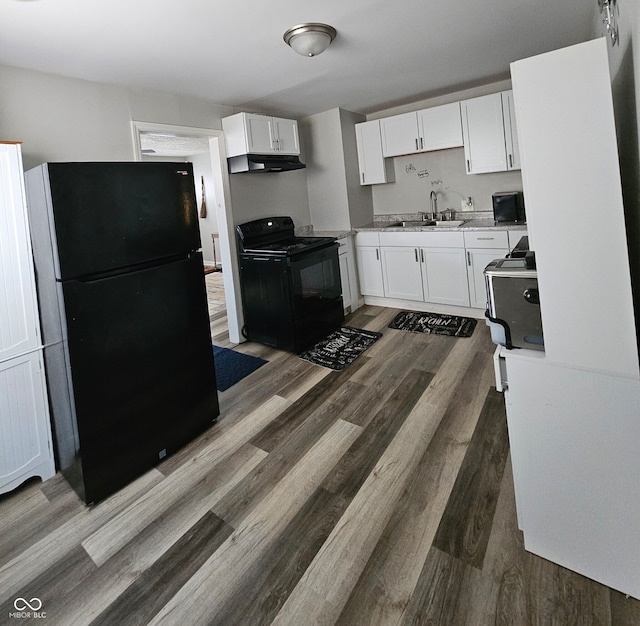 kitchen with dark wood-type flooring, white cabinetry, sink, and black appliances