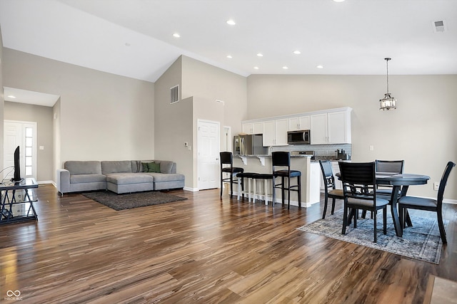 dining room featuring dark hardwood / wood-style floors and high vaulted ceiling