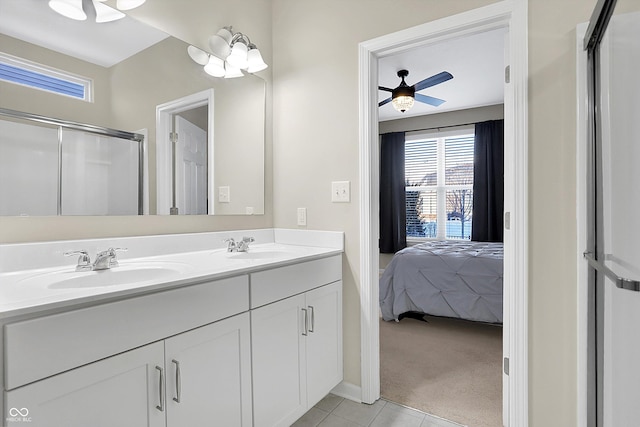 bathroom with tile patterned floors, ceiling fan, a shower with door, and vanity