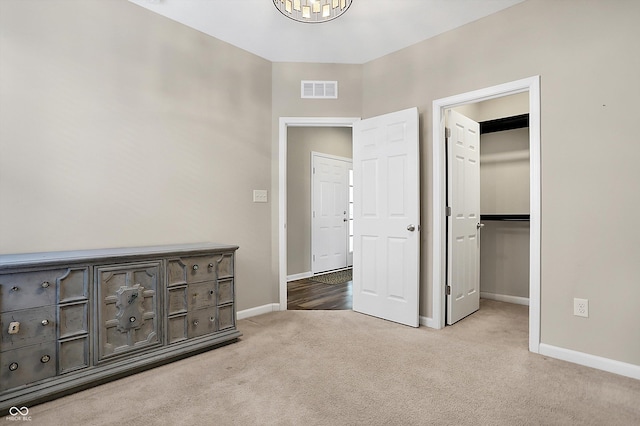 unfurnished bedroom with light carpet and a closet