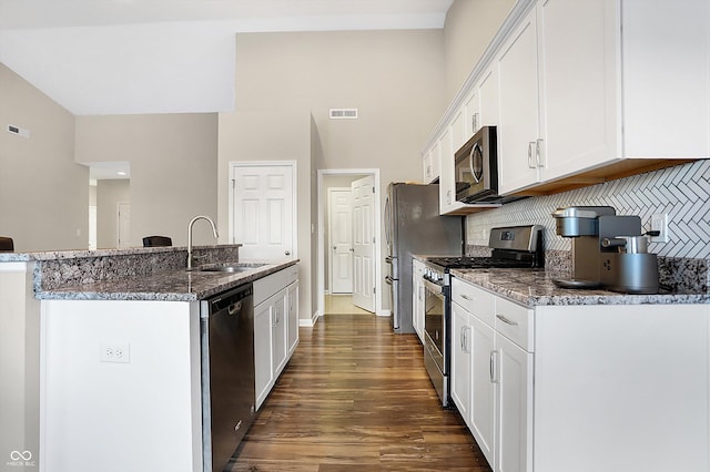 kitchen featuring sink, decorative backsplash, an island with sink, white cabinetry, and stainless steel appliances