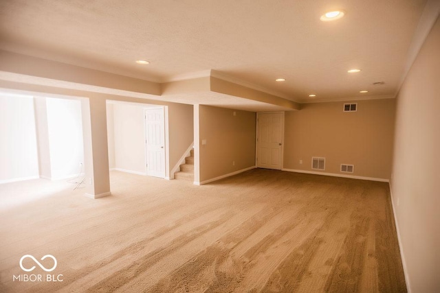 basement featuring crown molding and light colored carpet