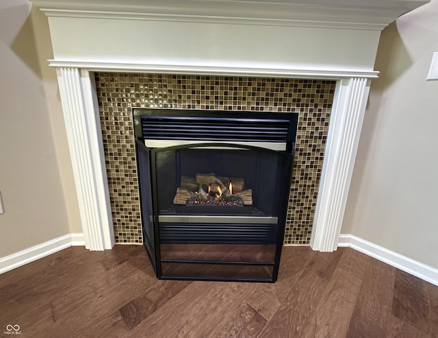 room details with a tiled fireplace, crown molding, and hardwood / wood-style floors