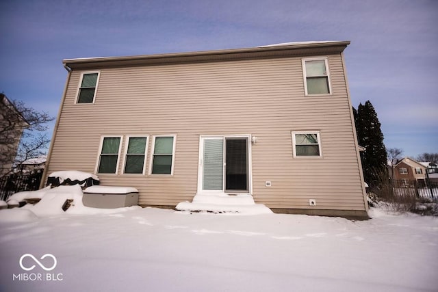 view of snow covered rear of property