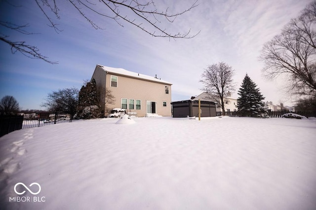 view of snow covered back of property