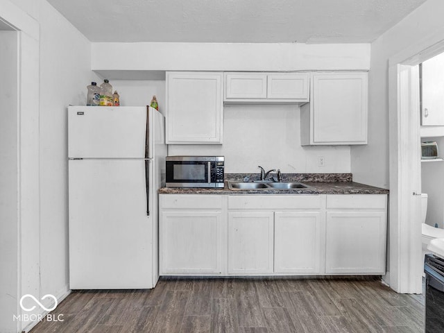 kitchen with dark hardwood / wood-style flooring, sink, white cabinets, and white refrigerator