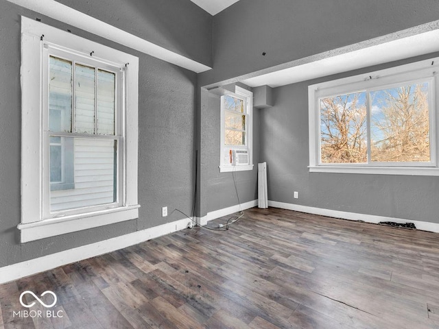 spare room featuring a wealth of natural light, dark hardwood / wood-style flooring, and cooling unit