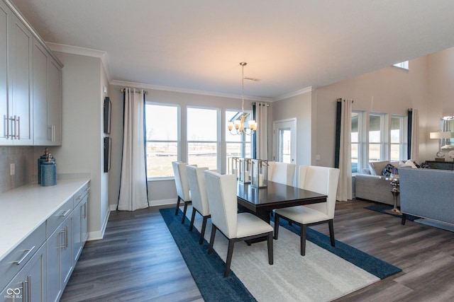 dining room featuring dark hardwood / wood-style floors, crown molding, and a notable chandelier