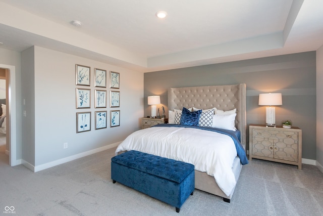 carpeted bedroom with a tray ceiling