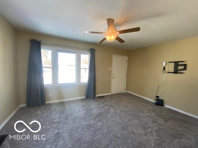 carpeted spare room with ceiling fan