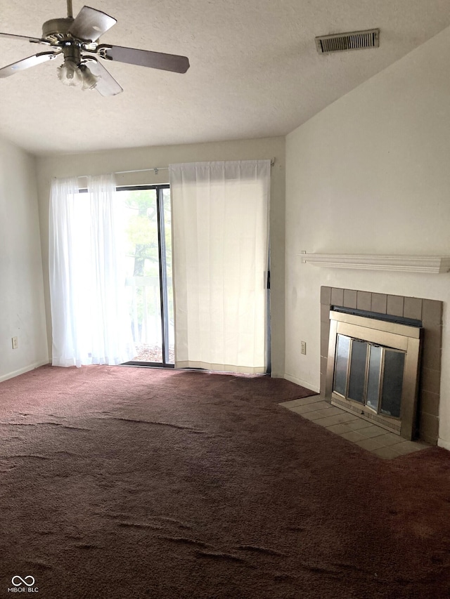 unfurnished living room featuring ceiling fan, carpet flooring, a textured ceiling, and a fireplace