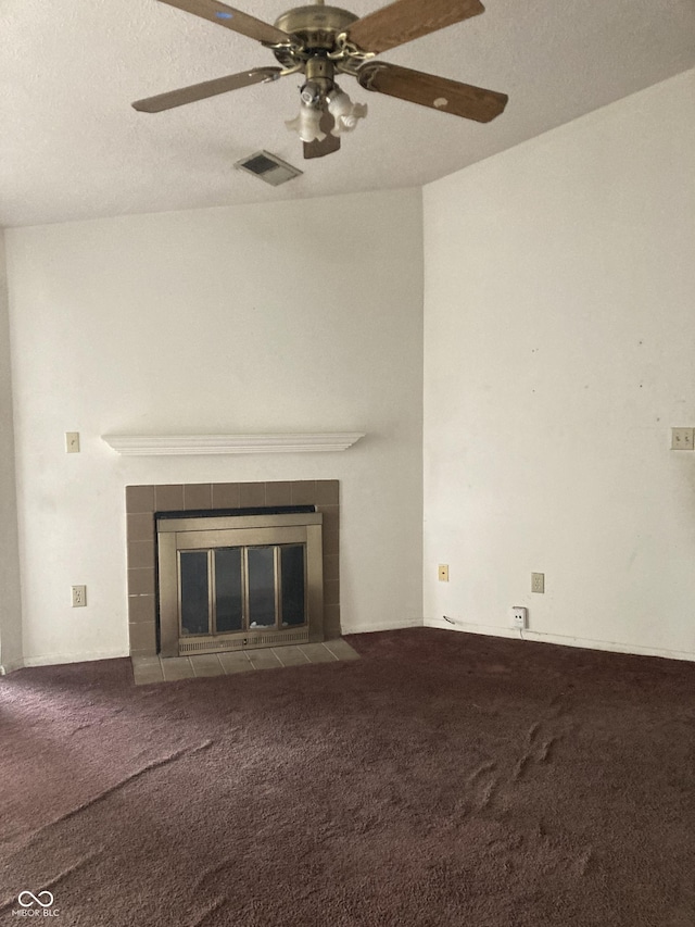 unfurnished living room with ceiling fan, carpet flooring, and a tile fireplace