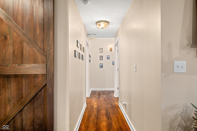 hallway with dark hardwood / wood-style flooring and a textured ceiling