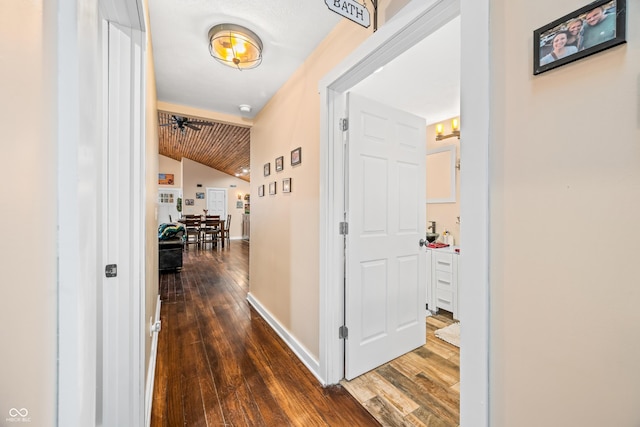 hall featuring dark hardwood / wood-style floors, wood ceiling, and lofted ceiling