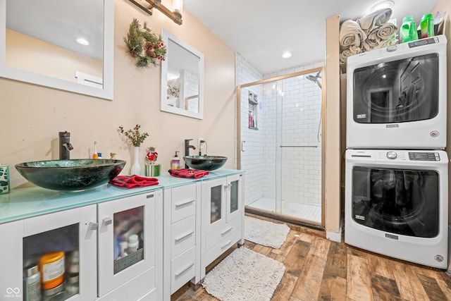 bathroom featuring stacked washer and dryer, vanity, hardwood / wood-style floors, and an enclosed shower