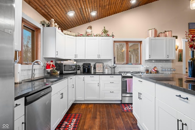 kitchen with lofted ceiling, backsplash, wooden ceiling, white cabinetry, and stainless steel appliances