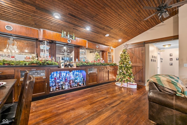 bar with a barn door, ceiling fan, wood ceiling, and hardwood / wood-style flooring