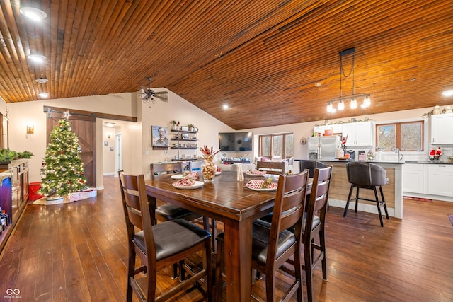 dining room with ceiling fan, dark wood-type flooring, a barn door, lofted ceiling, and wood ceiling