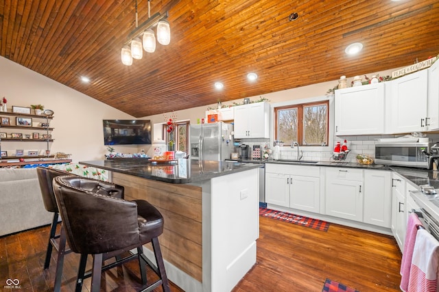 kitchen featuring stainless steel appliances, a kitchen island, and white cabinetry