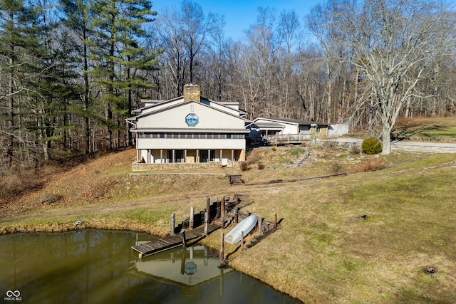 back of house with a yard and a water view