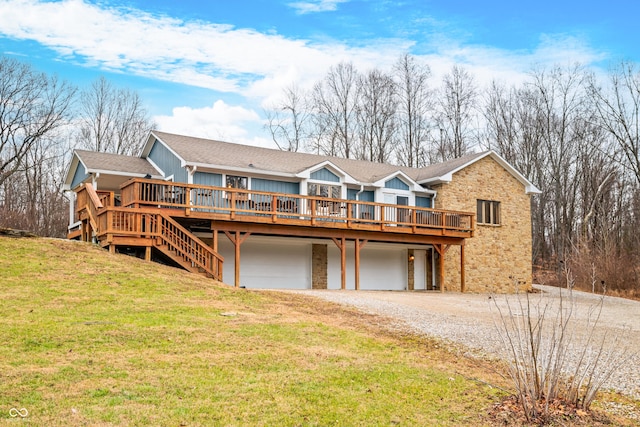 rear view of house with a garage, a deck, and a yard