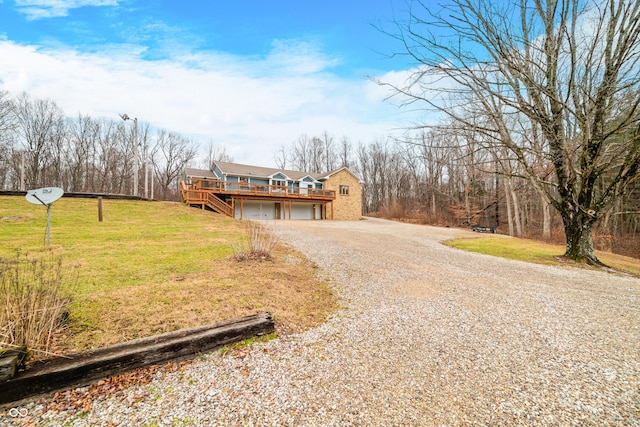 view of front facade featuring a wooden deck, a front lawn, and a garage