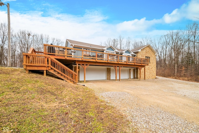 back of property with a wooden deck and a garage