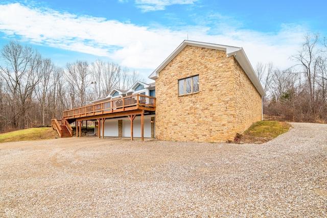 view of property exterior featuring a garage and a deck