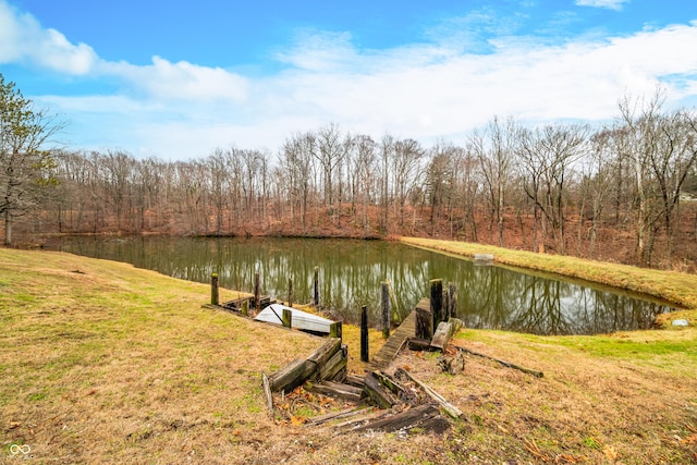 view of dock with a lawn and a water view