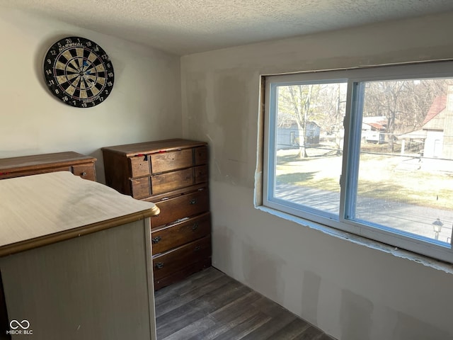 unfurnished bedroom with a textured ceiling and dark wood-type flooring