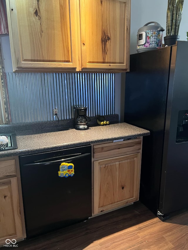 kitchen with black appliances and hardwood / wood-style flooring