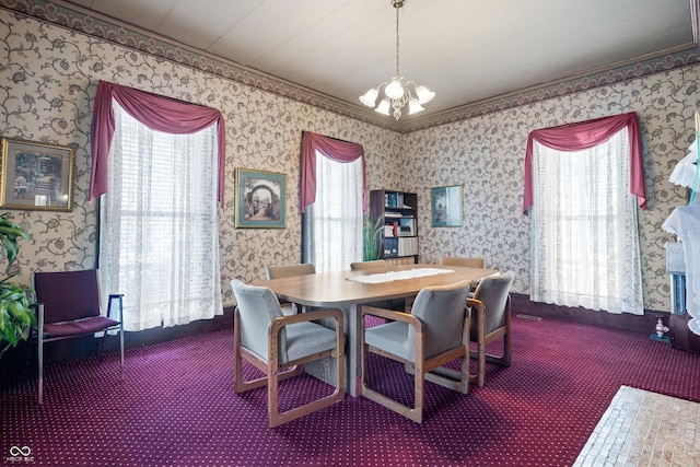 carpeted dining space featuring a chandelier, a wealth of natural light, and crown molding