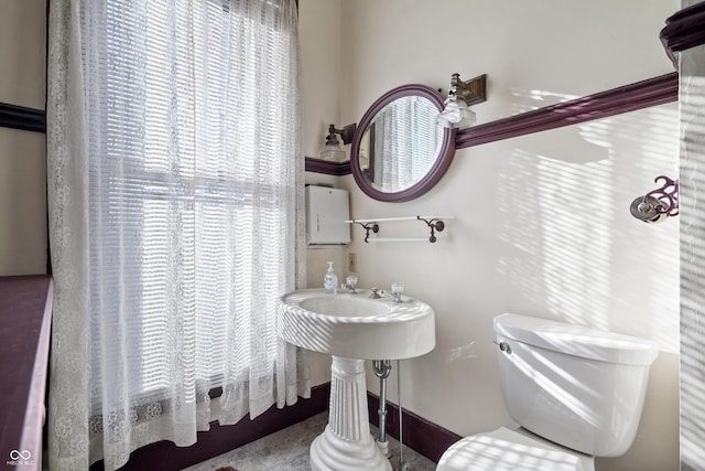 bathroom featuring a wealth of natural light and toilet