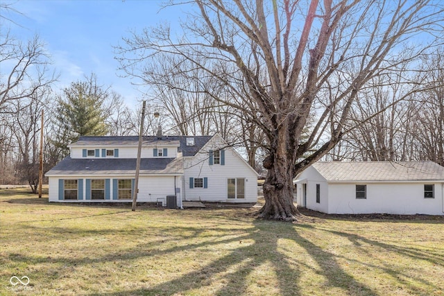 rear view of house with cooling unit and a yard