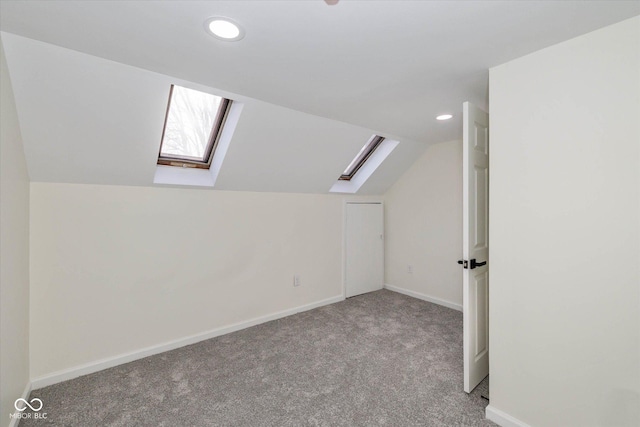 additional living space with lofted ceiling with skylight and light carpet