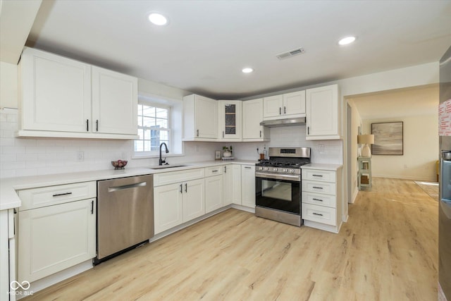 kitchen featuring stainless steel appliances, white cabinetry, and sink