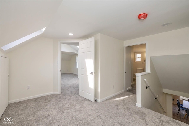 bonus room featuring light colored carpet and lofted ceiling with skylight