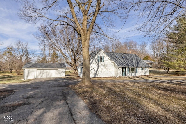 view of side of home with a garage and an outbuilding