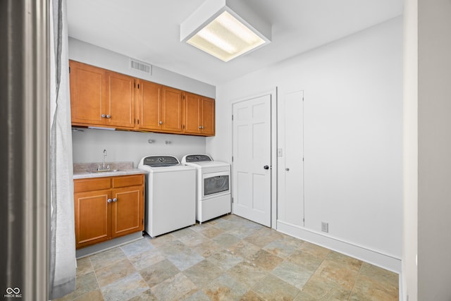 washroom featuring cabinets, independent washer and dryer, and sink