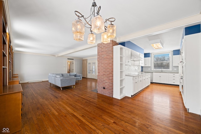 interior space with beamed ceiling, wood-type flooring, an inviting chandelier, and sink