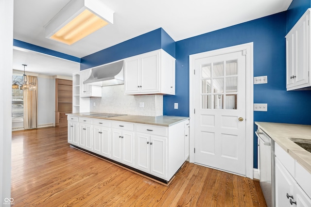 kitchen featuring stainless steel dishwasher, white cabinetry, hanging light fixtures, and wall chimney exhaust hood