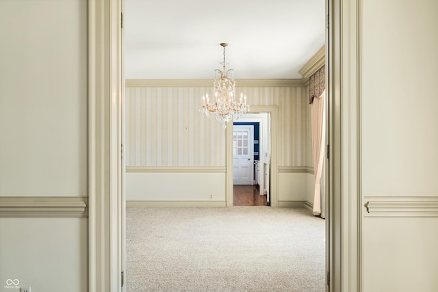 interior space with carpet flooring, a notable chandelier, and crown molding