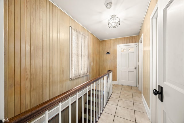 hallway featuring light tile patterned floors and wood walls