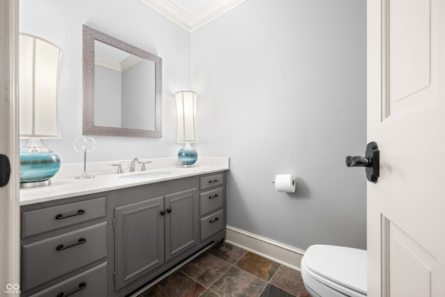 bathroom with vanity, toilet, and ornamental molding