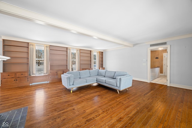 unfurnished living room with beam ceiling, built in shelves, and hardwood / wood-style flooring