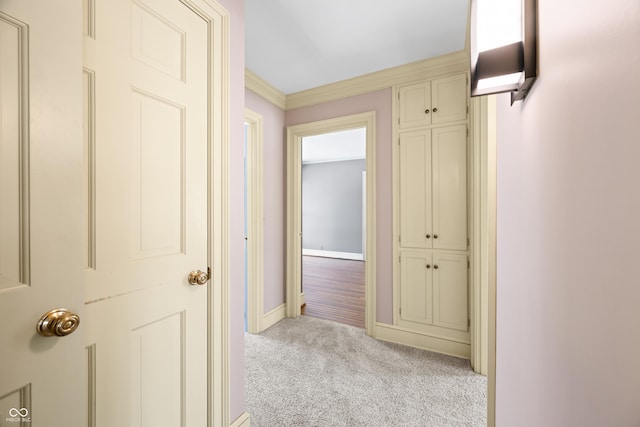 hallway with light colored carpet and ornamental molding