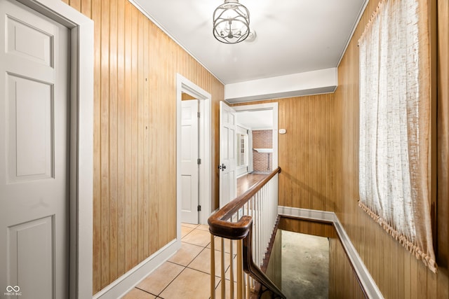 hall featuring wood walls and light tile patterned floors